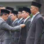 Prosesi penyerahan tanda kehormatan Satyalancana kepada penerima penghargaan.