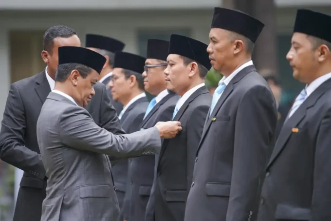 Prosesi penyerahan tanda kehormatan Satyalancana kepada penerima penghargaan.